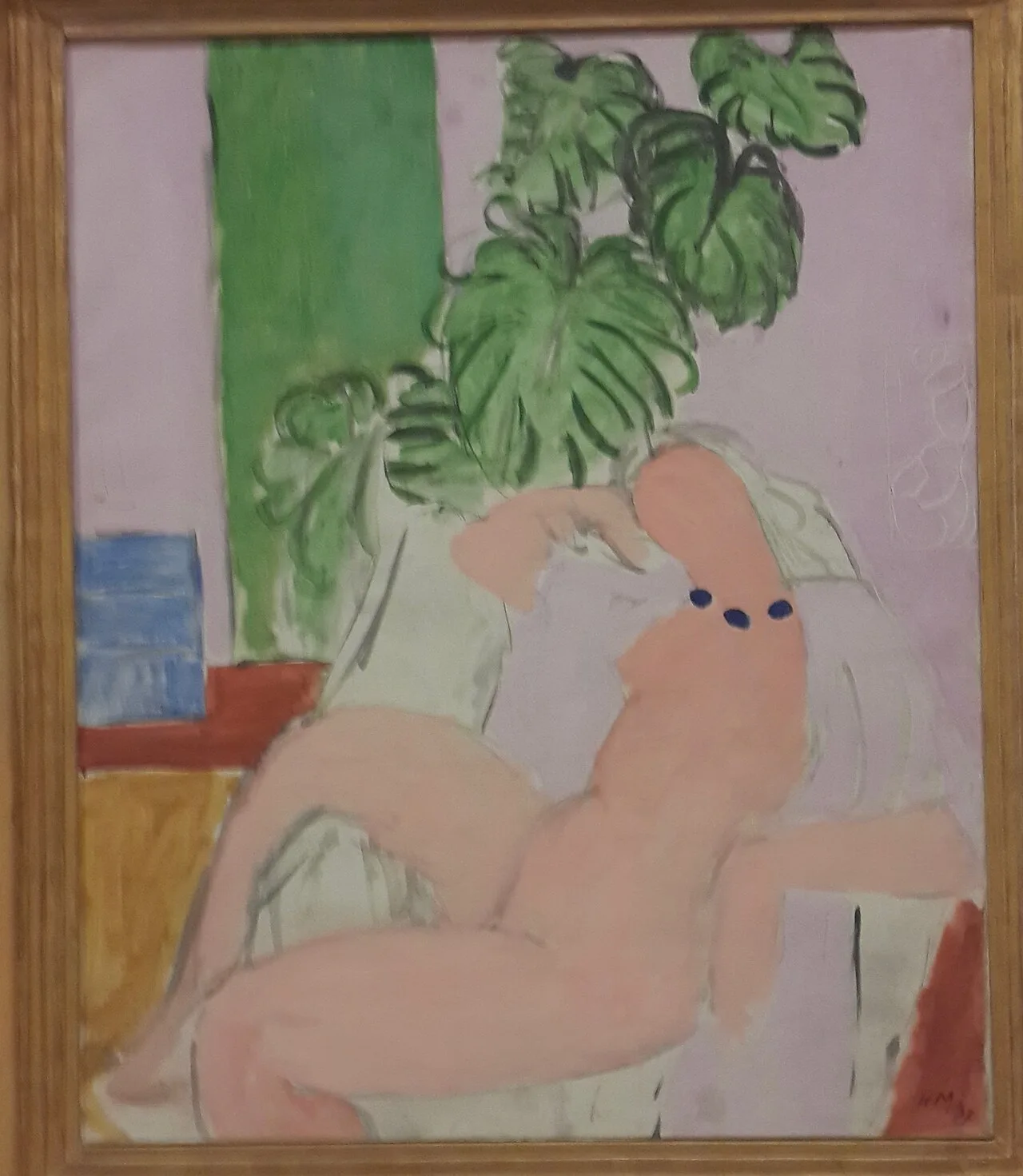 Nu dans un fauteuil, plante verte